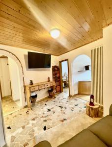 卡瓦萊塞的住宿－Tina's House - Alpine Stay Apartments，客厅设有木制天花板和平面电视。