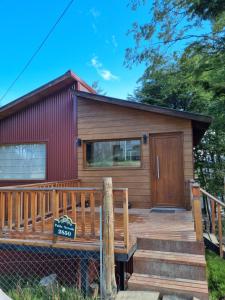 a log cabin with a deck and a house at LengaUsh in Ushuaia