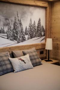 1 dormitorio con un mural de un bosque cubierto de nieve en Sci Sport rooms & suites en Bormio