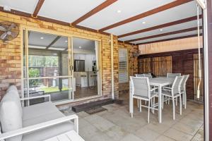 a dining room with a table and chairs on a patio at Regency 3 Bedroom Central Town House in Mooloolaba