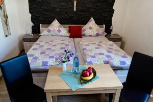 Un dormitorio con 2 camas y una mesa con un bol de fruta en AllerHand Gästezimmer Nohen en Nohen