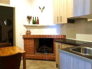 cocina con chimenea, fregadero y mesa en Preciosa vivienda rural en Alpujarra Almeriense, en Felix