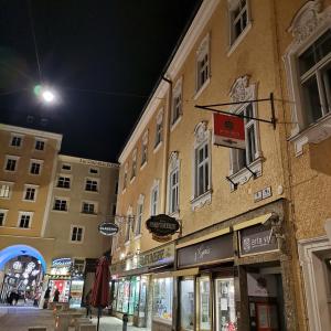 una calle de noche con tiendas y edificios en arte vida boutique guesthouse en Salzburgo