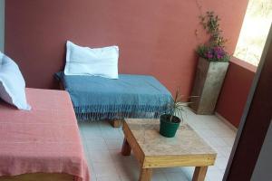 Habitación con 2 camas y mesa con maceta en departamento chateau en Córdoba