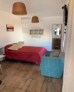 1 dormitorio con cama roja y sofá en Killa in 