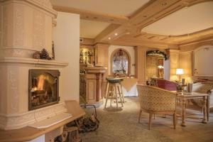 a living room with a fireplace and a kitchen at Hotel Chalet Del Sogno in Madonna di Campiglio