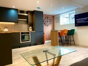 una cucina con tavolo in vetro in una camera di Smart/ Modern one bedroom flat a Purley