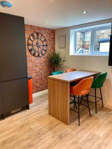 une chambre avec une table, des chaises et une horloge dans l'établissement Smart/ Modern one bedroom flat, à Purley