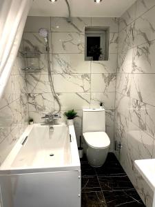 ein Badezimmer mit einer Badewanne, einem WC und einem Waschbecken in der Unterkunft Smart/ Modern one bedroom flat in Purley