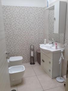 ein weißes Bad mit einem WC und einem Waschbecken in der Unterkunft B&B Sophie in Neapel