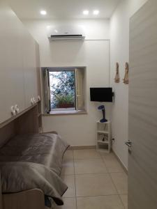 Schlafzimmer mit einem Bett, einem Fenster und einem TV in der Unterkunft B&B Sophie in Neapel