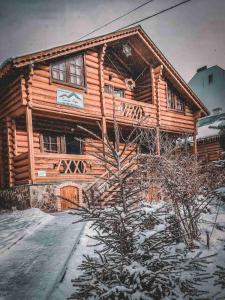 a log cabin with snow on the ground at Котедж Синя гора in Bukovel