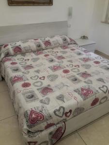 ein Bett mit einer Bettdecke mit Herz drauf in der Unterkunft B&B Sophie in Neapel