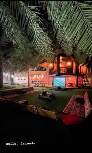 a living room with a palm tree and a tv at منتجع اكواخ النخيل in Al Muţayrifī
