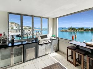 a kitchen with a view of the water at Blue on Blue Superior Studio Room 1271 in Nelly Bay
