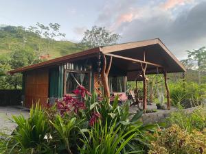 Chorotega Cabina في مونتيفيردي كوستاريكا: منزل صغير في حديقة بها زهور
