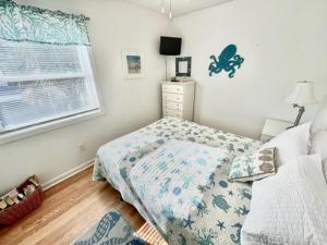 a small bedroom with a bed and a window at Boston Commons 101 Condo in Myrtle Beach