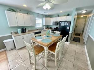 a kitchen with a wooden table and white cabinets at Boston Commons 101 Condo in Myrtle Beach