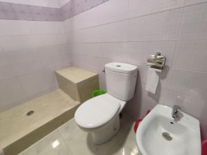 a white bathroom with a toilet and a sink at Appartement Casablanca Anfa in Casablanca