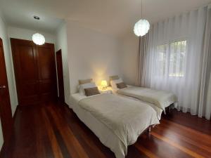 a bedroom with two beds and a window at Neves by BCA Villas in São Gonçalo
