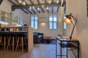 salon i kuchnia z kanapą i stołem w obiekcie Appartement climatisé entièrement rénové en hyper centre! Le Rétro Chic - Parking gratuit - Linge et serviettes inclus - w mieście La Roche-Chalais