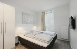 トラフェミュンデにあるPromenadenvillaの白いベッドルーム(ベッド1台、窓付)