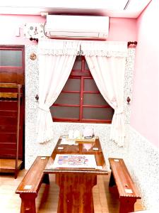 a room with a red door and a table and a window at Yi-Shiou Home in Taitung City