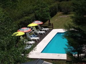 a swimming pool with umbrellas and lounge chairs next to it at Cabañas La Herradura in Villa Ciudad Parque