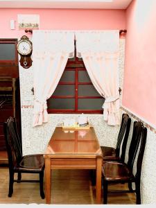 a dining room table with two chairs and a clock at Yi-Shiou Home in Taitung City