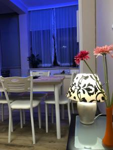 a dining room with a table and chairs and flowers at Ani Apartament in Durrës