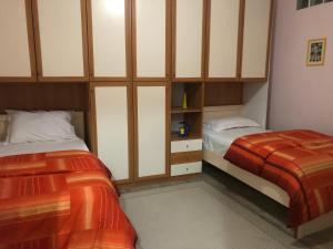 ein Schlafzimmer mit 2 Betten und Schränken in der Unterkunft Ani Apartament in Durrës