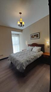 Un dormitorio con una cama grande y una lámpara de araña. en Quinta Manuela en Mendoza