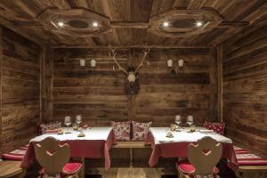 マドンナ・ディ・カンピリオにあるHotel Chalet Del Sognoの木製の壁のレストランのテーブル2台