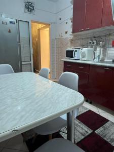a kitchen with a table and chairs and a microwave at Sophia Lupeni Straja in Lupeni