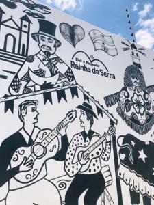 a mural of a group of people playing music at Flat Rainha da Serra in Bezerros