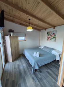 a bedroom with two beds and a television in it at Cabañas Koyam in Melipeuco