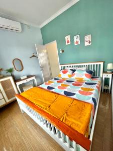 ein Schlafzimmer mit einem großen Bett mit einer bunten Bettdecke in der Unterkunft Rumah Paron Homestay Barat in Yogyakarta