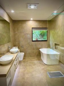 ein Badezimmer mit zwei Waschbecken, einer Badewanne und einem Fenster in der Unterkunft Melbourne Topview Villa in Dandenong ranges near Skyhigh in Kalorama