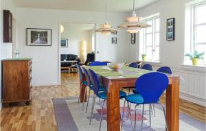 a dining room with a table and blue chairs at Stunning Home In Gudhjem With Kitchen in Gudhjem
