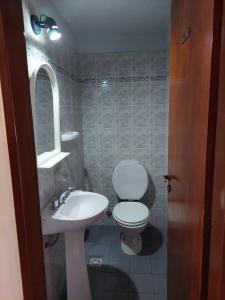 y baño con aseo blanco y lavamanos. en Casa luminosa y Acogedora en Ushuaia