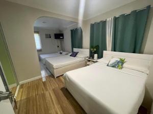 una camera d'albergo con due letti e un divano di Phuenics de galera a Puerto Galera