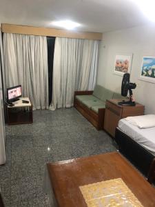 フォルタレザにあるAtlântico Flat Residenceのベッドとソファとテーブルのある寝室