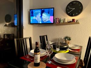 stół jadalny z butelką wina i zegarem w obiekcie Le Val d'Huez, Vue sur le Village et le Domaine w mieście LʼHuez
