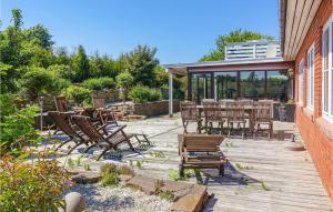 a patio with chairs and tables on a deck at Nice Home In Allinge With 3 Bedrooms And Wifi in Allinge