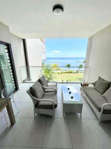 een woonkamer met uitzicht op de oceaan bij Luxury beach house with spectacular sea view and pool in Trou aux Biches