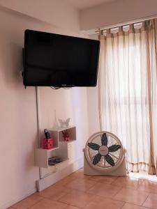 TV de pantalla plana colgada en una pared con ventilador en Welcome MDP Solo familias en Mar del Plata