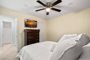 1 dormitorio con cama blanca y ventilador de techo en Cozy 2 Bedroom Duplex In Charlotte, Jacuzzi, Sleeps 6 plus 2, en Charlotte