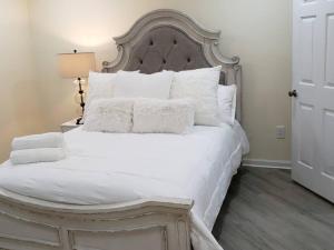 Cozy 2 Bedroom Pineville-Matthews Duplex Sleeps 8 في تشارلوت: سرير أبيض عليه أغطية ووسائد بيضاء