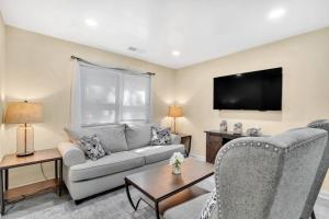 uma sala de estar com um sofá e uma televisão em Cozy 2 Bedroom Pineville-Matthews Duplex Sleeps 8 em Charlotte