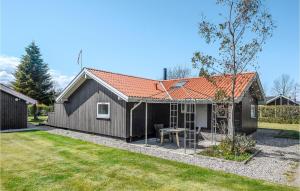 a black shed with a table in a yard at Awesome Home In Otterup With Kitchen in Otterup